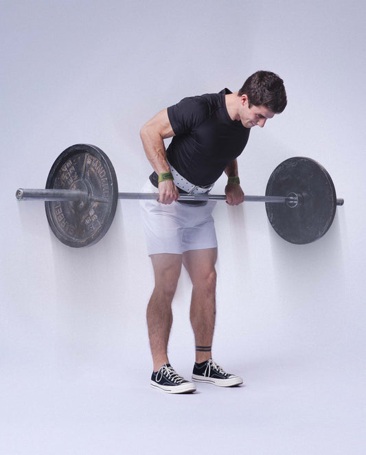 man doing barbell rows with uppper lifting straps and lifting belt