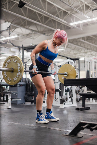 woman doing barbell row using uppper lifting belt and lifting straps