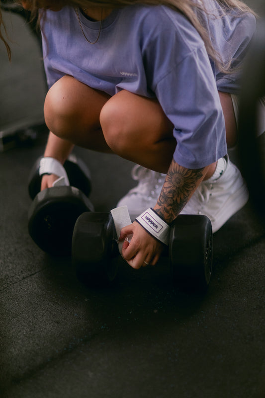 woman using white lifting straps uppper