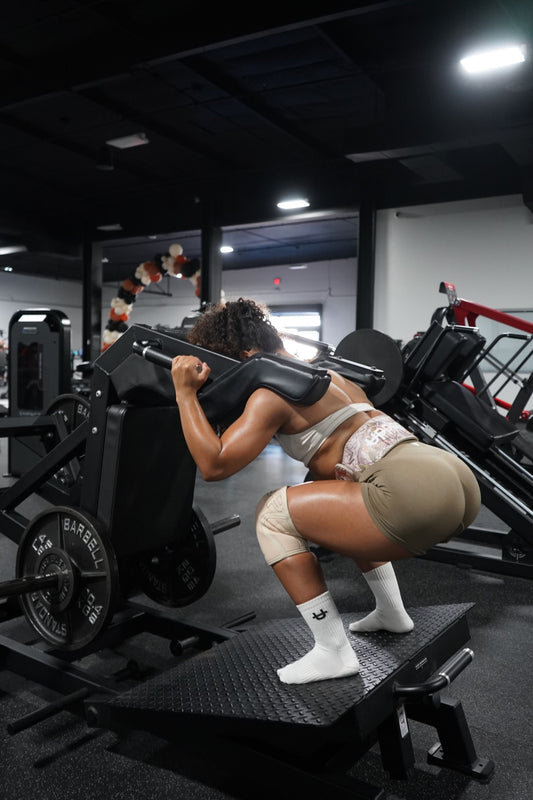 woman using leg machine at the gym using uppper lifting gear