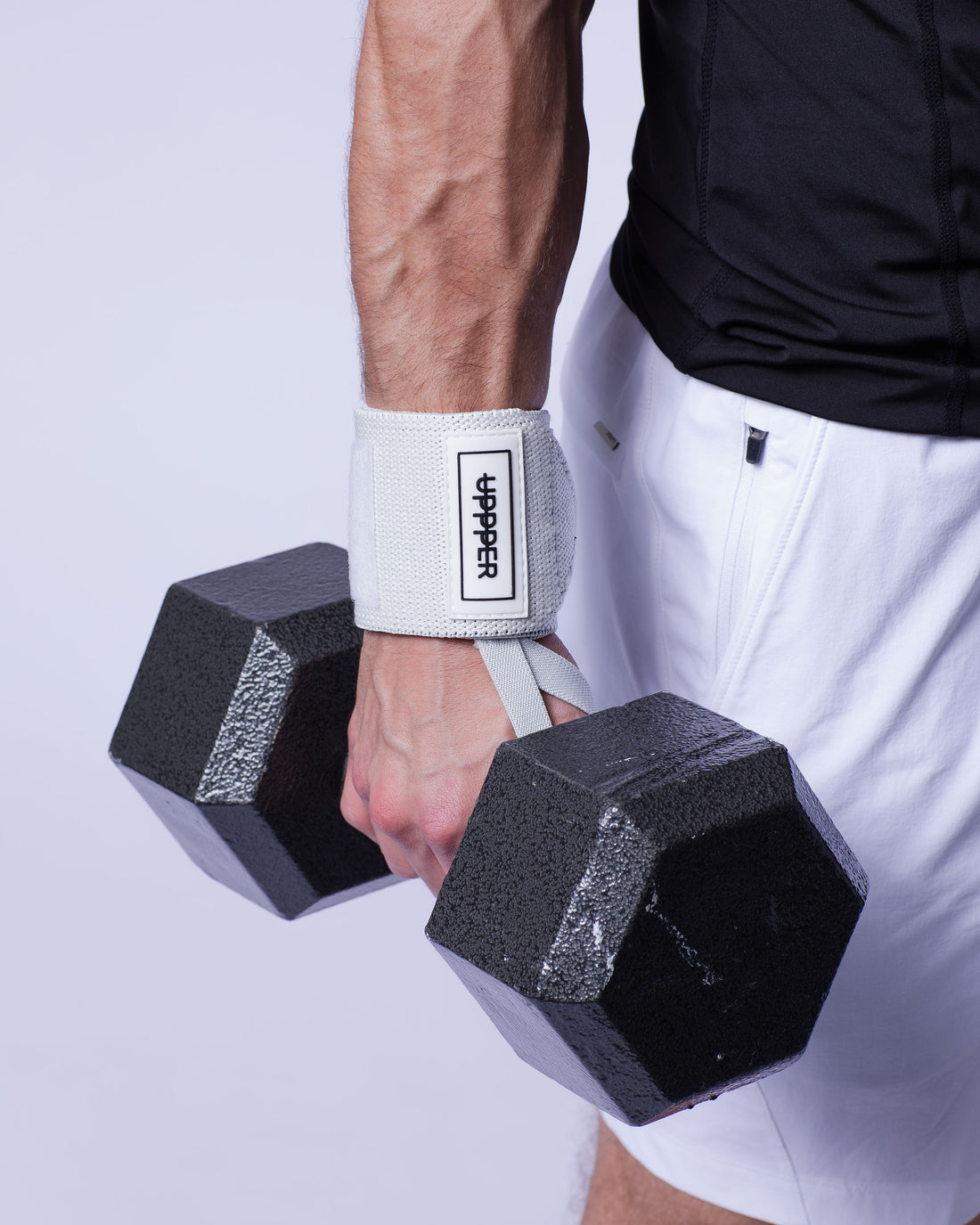 man gripping dumbbell using uppper wrist wraps